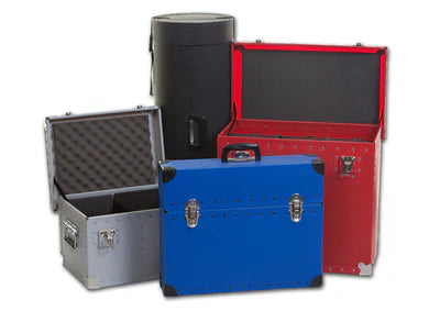 Four rugged shipping cases of various shapes and colors, including blue, red, gray, and black, with two cases open to show foam-lined interiors.