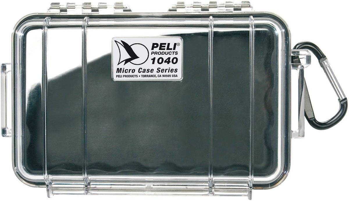 A closed 1040 PELI Micro™ Case with a clear top, black base, silver latch, attached carabiner, and product label on the lid. This crushproof case keeps your valuables protected wherever you go.