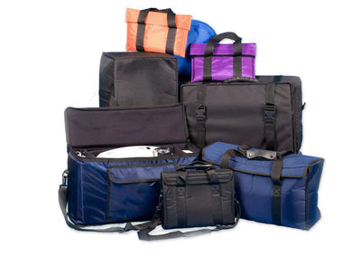 A variety of bags and cases in different colors, shapes, and sizes are arranged together, some open and some closed.