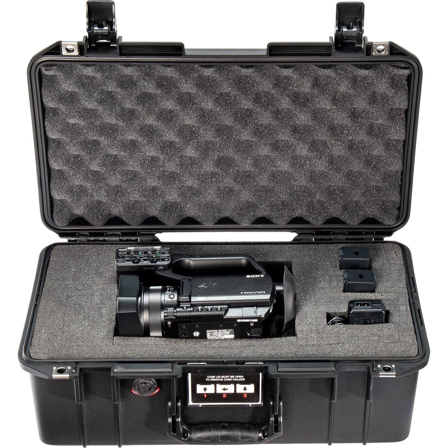 The 1506 Air Case, a lightweight waterproof PELI protective case with custom foam, securely holds a professional video camera, two batteries, and accessories—all neatly organized inside.