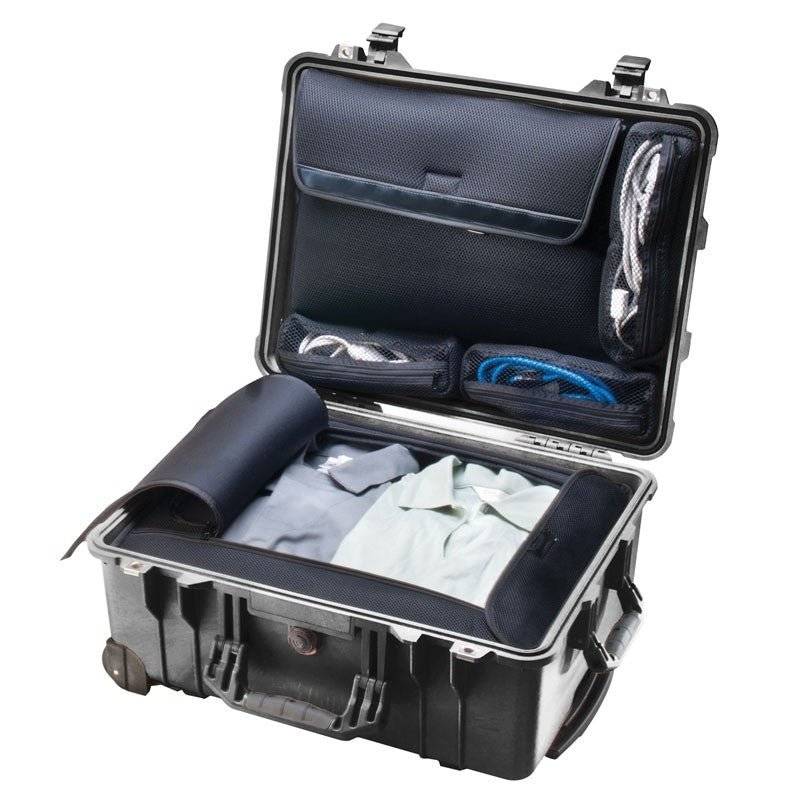 An open 1560LOC Protector Laptop Case with organized compartments holds folded clothes, coiled cables, and a rolled-up item, all set against a white background.