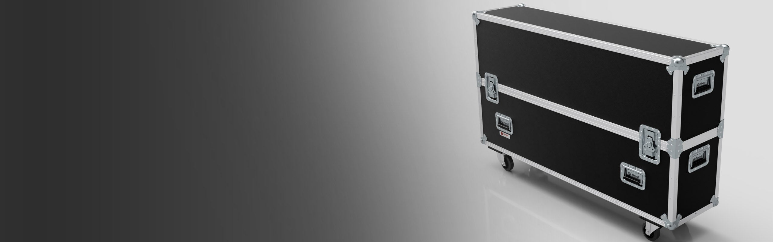 A large black equipment case with metal edges, handles, and wheels is positioned on a white and gray gradient background.