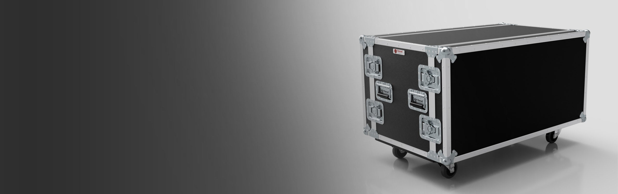 A large black road case with silver metal edges and hardware, featuring four wheels and handles, is positioned on a light background.