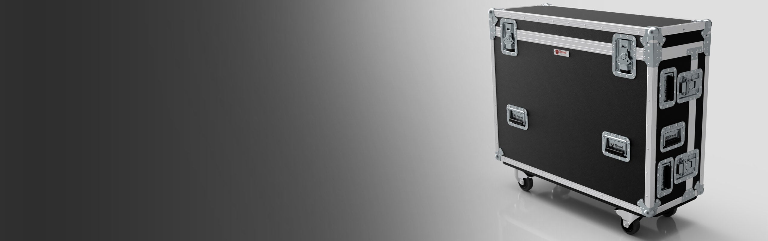 A large black and silver hard case with metal edges and latches, standing on four caster wheels, against a gradient gray background.
