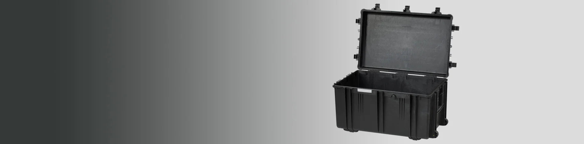 A large, black hard-shell protective case with an open hinged lid is displayed against a gradient grey background.