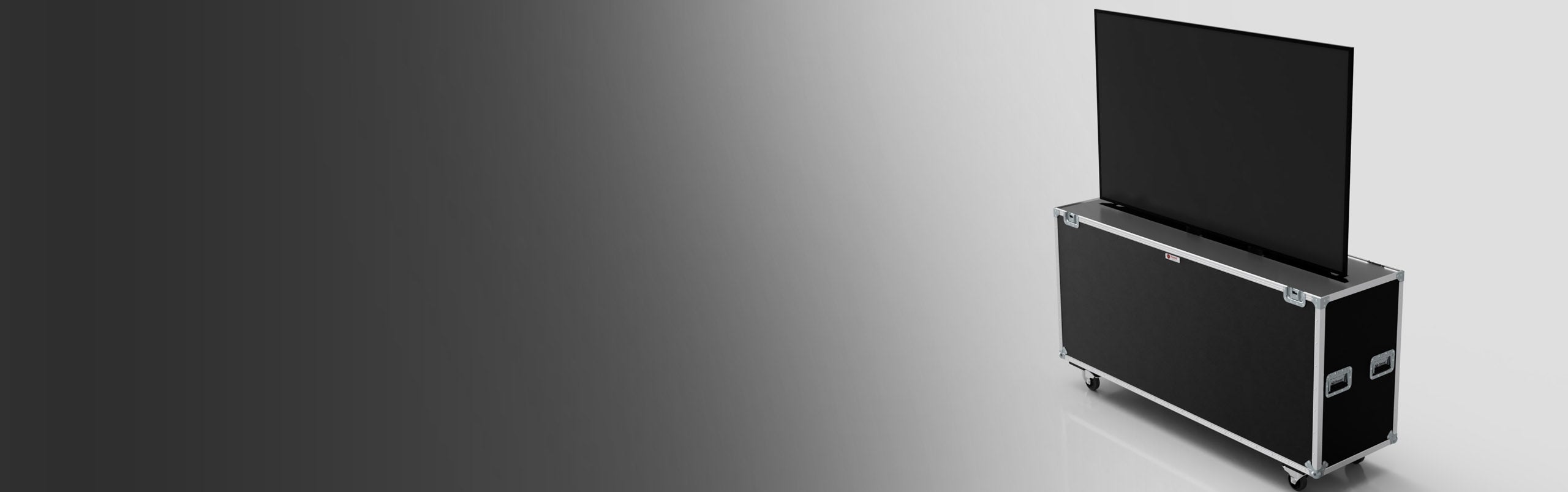 A large flat-screen TV is partially raised from a black rolling storage case on a grey gradient background.