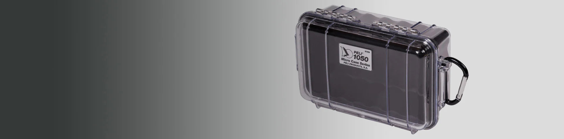 A transparent hard plastic protective case with a label reading 1060 Micro Case Series and a black carabiner attached.