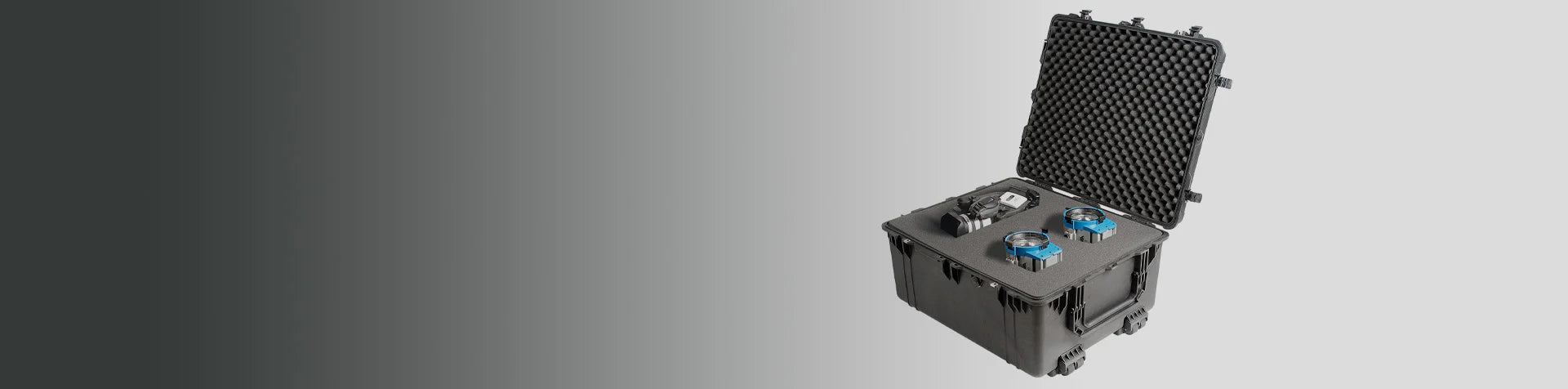 A black hard-shell carrying case with foam padding is open, displaying two blue devices and a black electronic component inside.