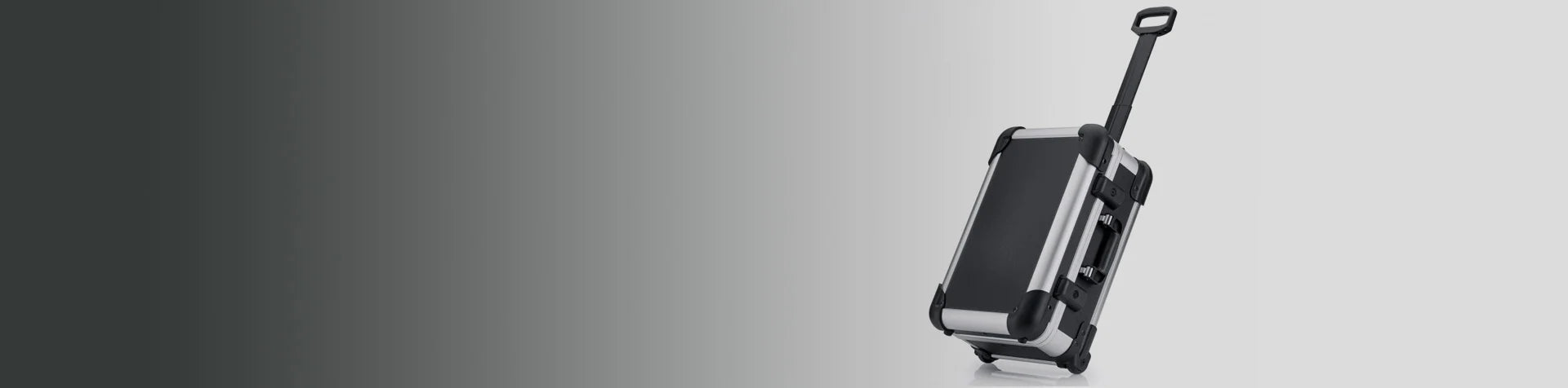 A black hard-shell rolling suitcase with an extended handle is shown on a light background with a gradient effect.