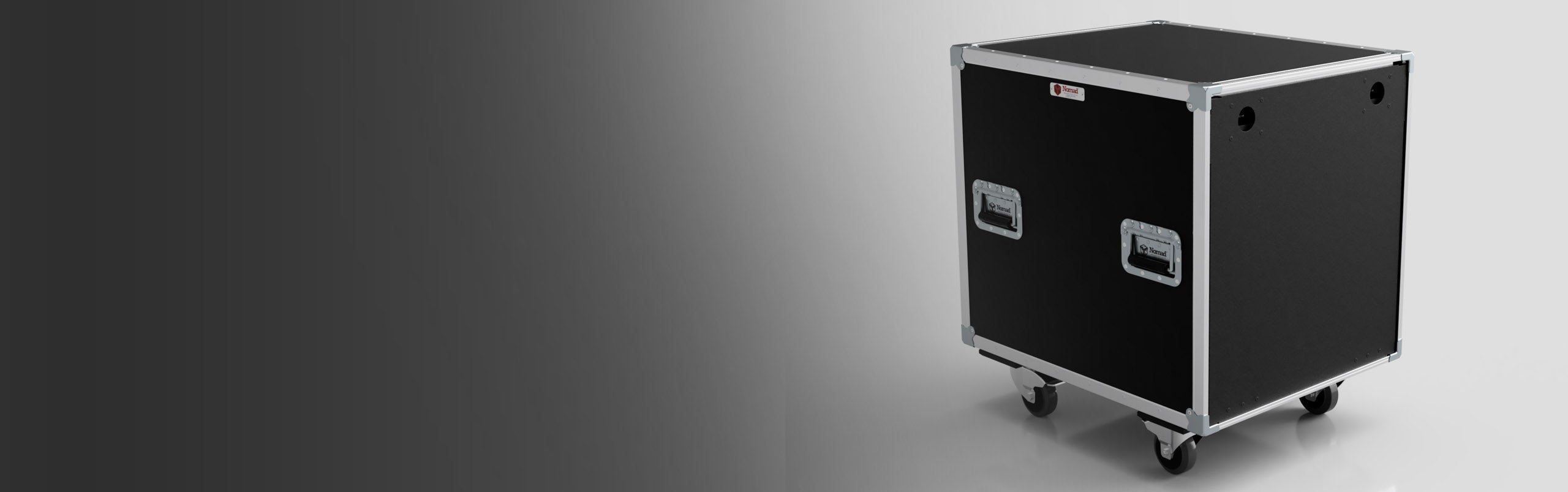 A black rectangular flight case with metal edges, handles, and wheels, positioned against a gradient gray background.