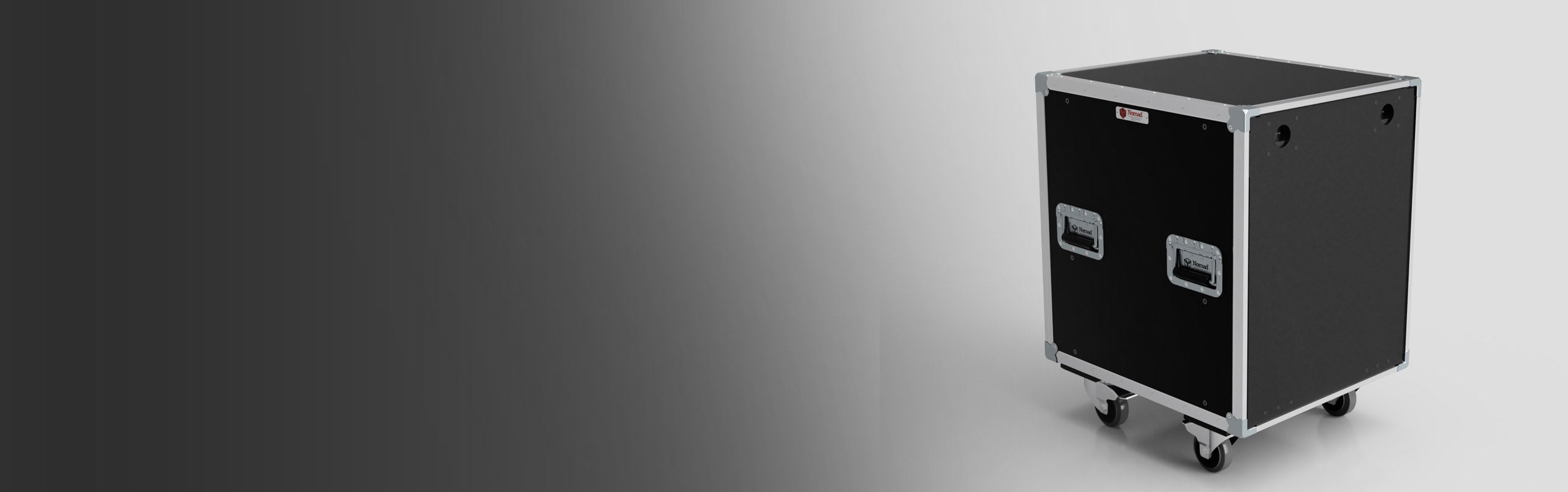 A black, rectangular rolling equipment case with metal edges, handles, and four wheels is positioned on a light surface with a gradient background.