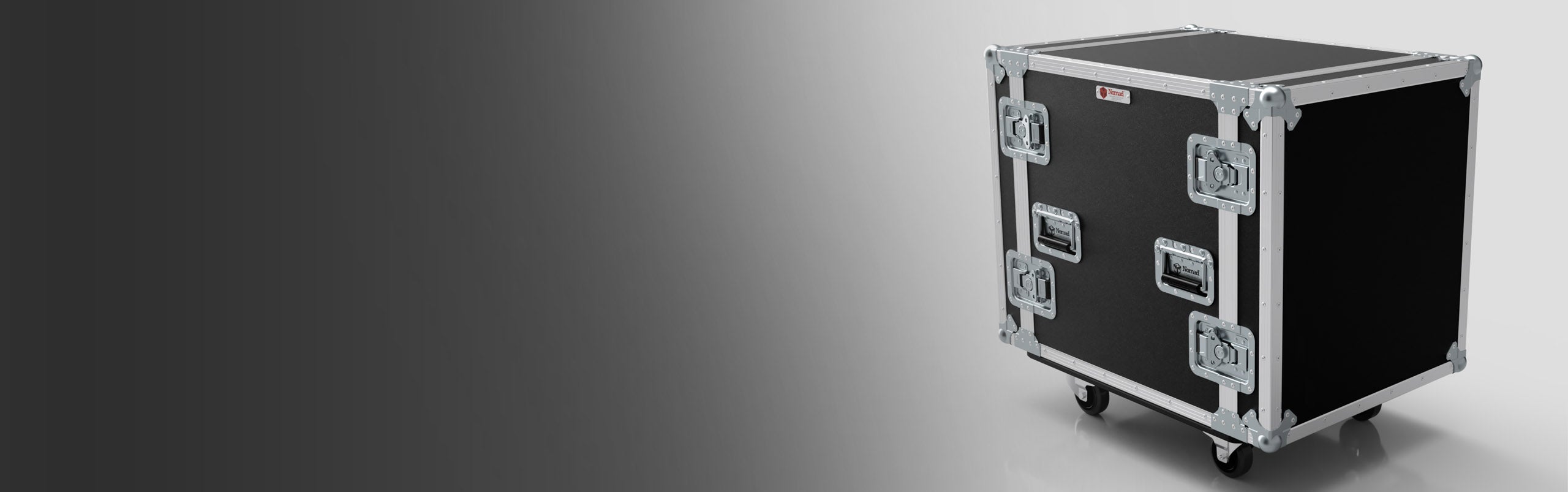 A black road case with metal reinforcements, handles, and latches stands on wheels against a gradient grey background.