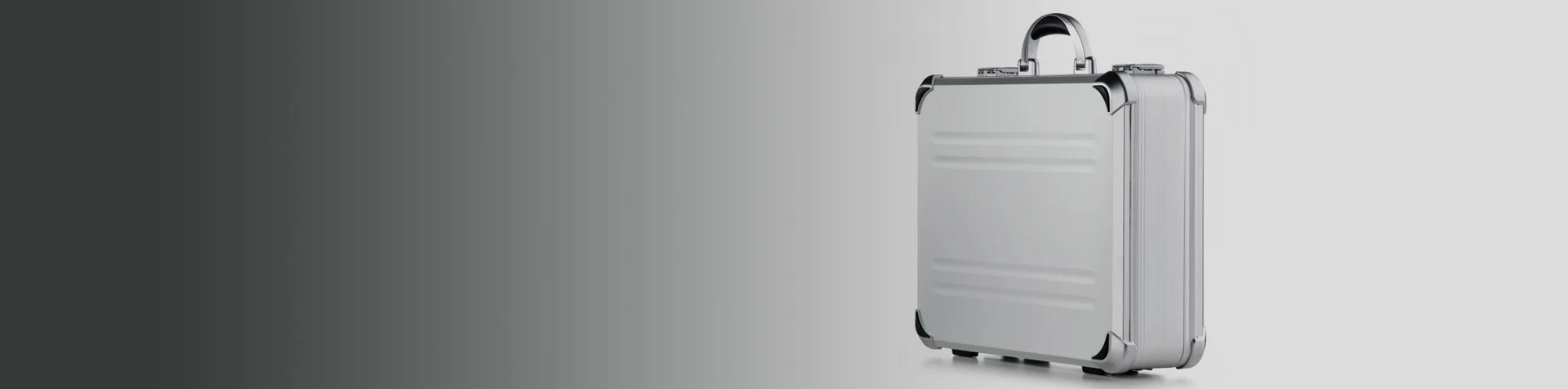 A silver hard-shell briefcase with black corner protectors and a chrome handle is placed on a plain gradient background.