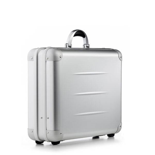 The ALUpur 98300, a silver anodised aluminium case with rounded edges, metal hinges, and a metallic handle, stands upright against a plain white background.