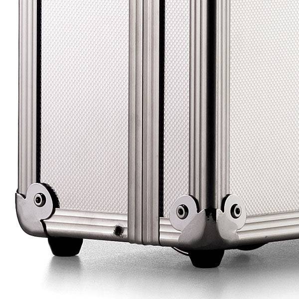 Close-up of the bottom corner of the ARK 90100 field work case, highlighting its silver hard-shell exterior, aluminum frame, metal reinforcements, and small black feet.