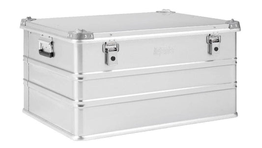 The Defender KA64-010, a large silver 155L case with reinforced corners, side handles, and two front latch closures, is displayed against a white background.