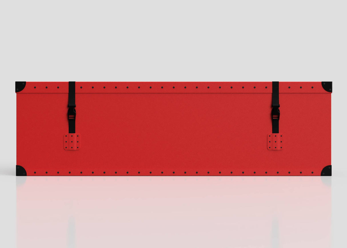 The Football Storage Poly Case (Large) is a long, flat red rectangular polyethylene box with black corner protectors and two black straps with webbing buckle fastenings, shown on a plain light background.