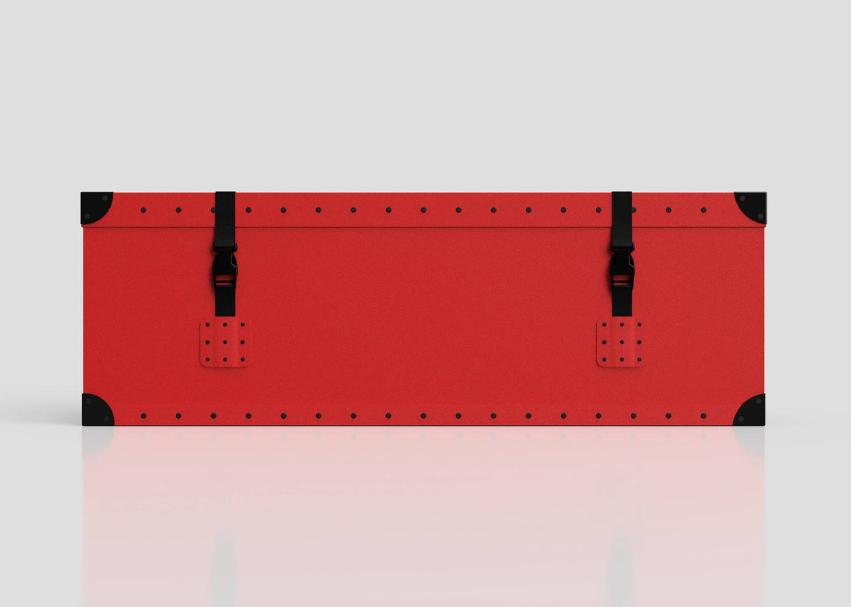 The Football Storage Poly Case (Small) is a rectangular red polyethylene box with black corner protectors, riveted edges, a zinc drop handle, and two black buckle straps on the front, shown against a plain light background.