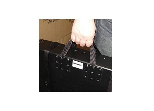 A person holds a black Heavy Duty Photographic Print Box 1.625" (without webbing handle); the box features a label reading Nomad and has metal rivets near the handle area.