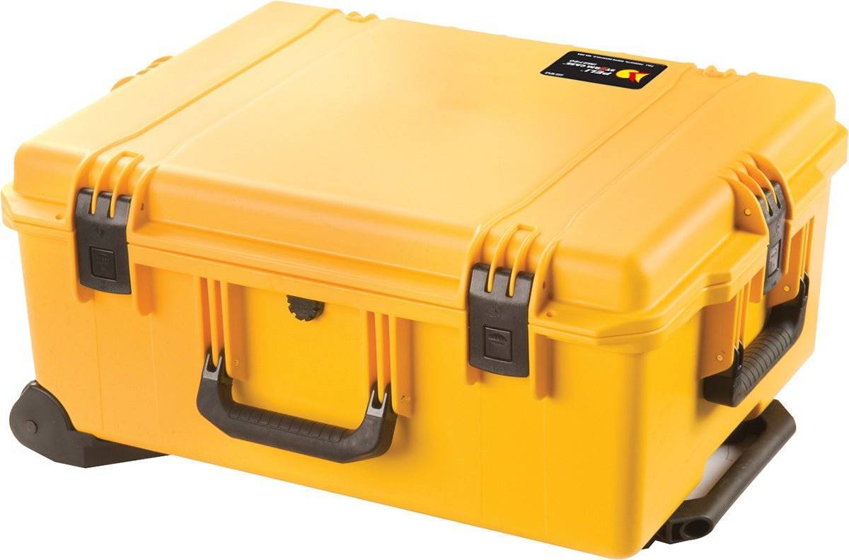 A yellow iM2720 Storm Travel Case with black Press and Pull latches, a handle, and custom CNC foam fittings sits on a flat surface.