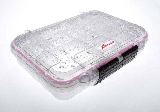 The MAX002T is a clear polypropylene copolymer waterproof storage box with water droplets on its lid and a black side handle, placed on a white surface.