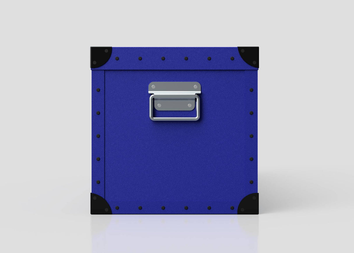 The Rugby Storage Poly Case (Medium) is a blue polyethylene box with black corner protectors, metal rivets, and a zinc drop handle on the front, shown against a plain white background.
