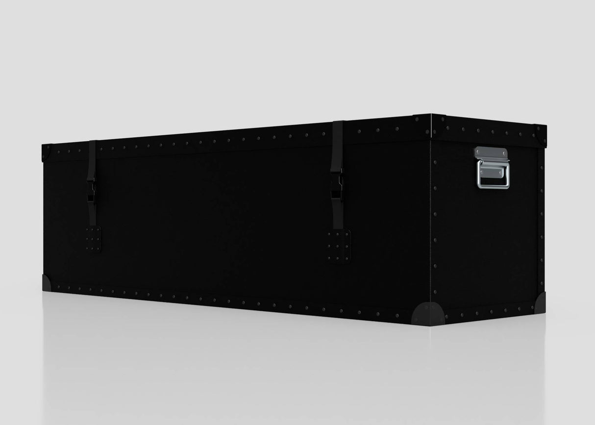 The Standard Long Storage Box - Large is a black, rectangular trunk with metal rivets, corner protectors, two front latches, and a zinc drop handle, shown on a plain white surface.