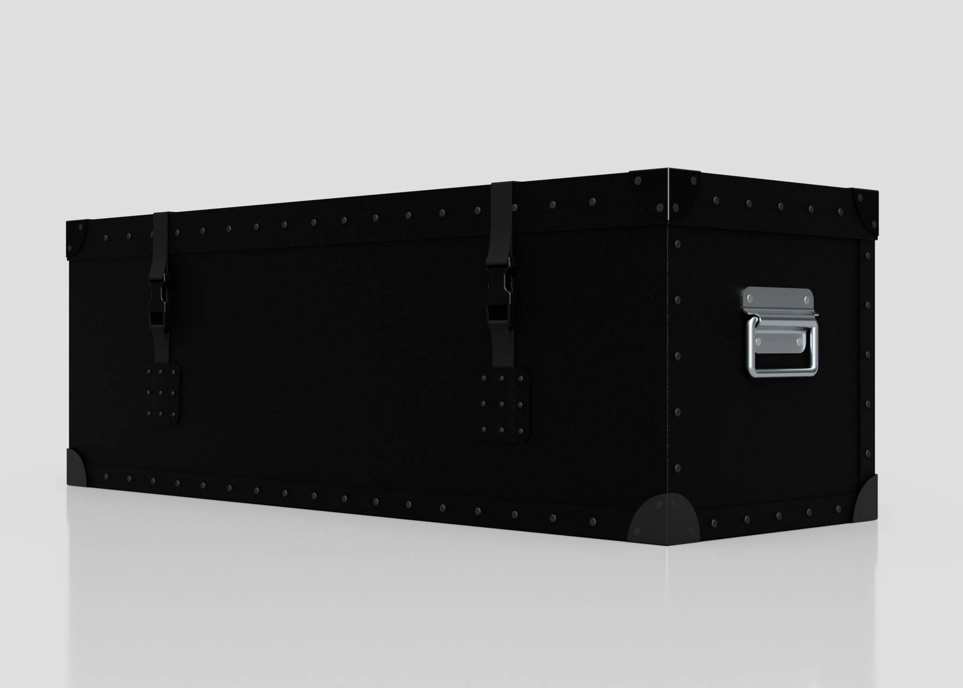 The Standard Long Storage Box - Small is a black metal trunk featuring rivets, corner protectors, front latches, and a zinc drop handle on the side, displayed against a plain light background.