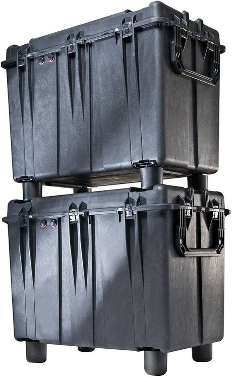 Two large black 0500 Protector Transport Cases with handles are stacked, with the top watertight case supported by raised feet on the bottom crushproof case.