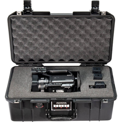 The 1506 Air Case, a lightweight waterproof PELI protective case with custom foam, securely holds a professional video camera, two batteries, and accessories—all neatly organized inside.