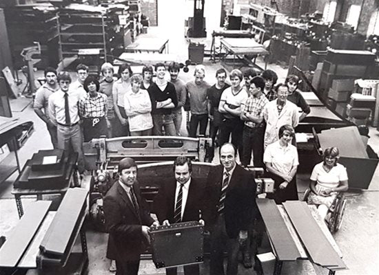 A group of people standing in a factory.