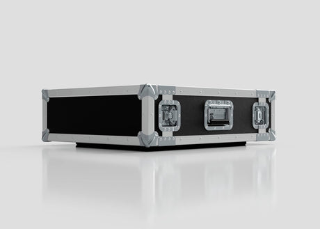 The 2U Suspended Shock Mounted Rack Case in black and silver features metal reinforced edges, corner protectors, and locking latches. Its shock mounted rack design provides extra impact protection while sitting on a reflective white surface.