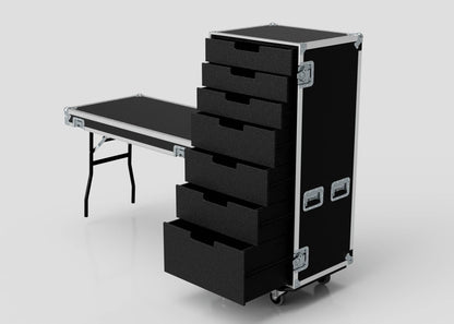A 7 Drawer Production Case in black with open drawers stands beside a fold-out black Side Attaching Trestle Table with metal legs, both set against a plain light background.
