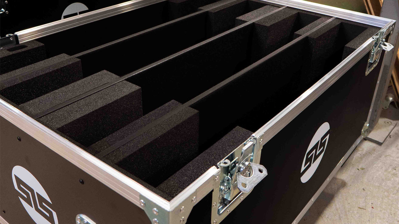 A large, open equipment case with foam dividers and metal latches, designed for organized storage and protection of items.