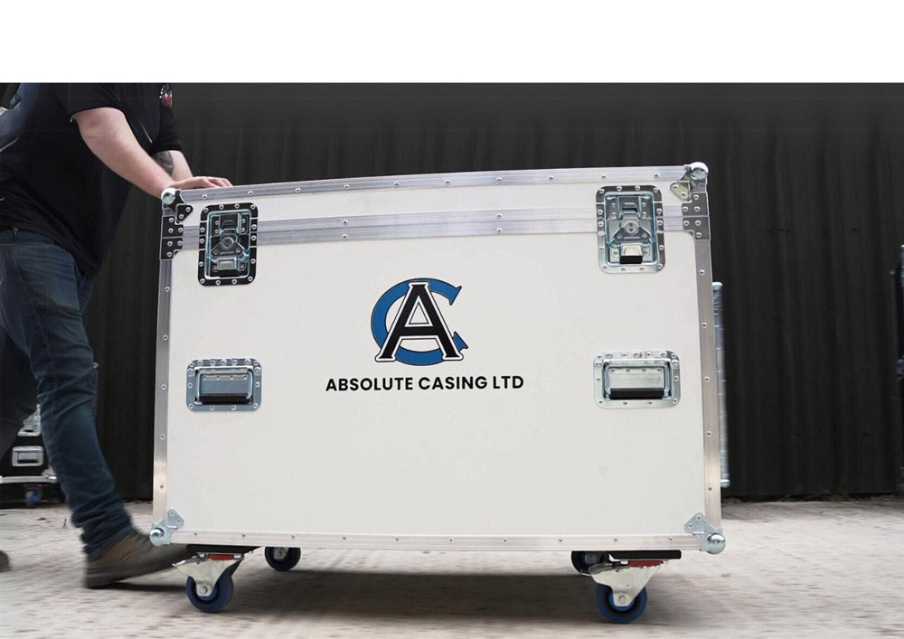 A person pushes a large white rolling case labeled Absolute Casing Ltd with metal handles and latches against a dark background.