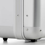 Close-up of the bottom corner of the ALUpur 98400 anodised aluminium case, featuring metal rivets and black wheels on a light surface.