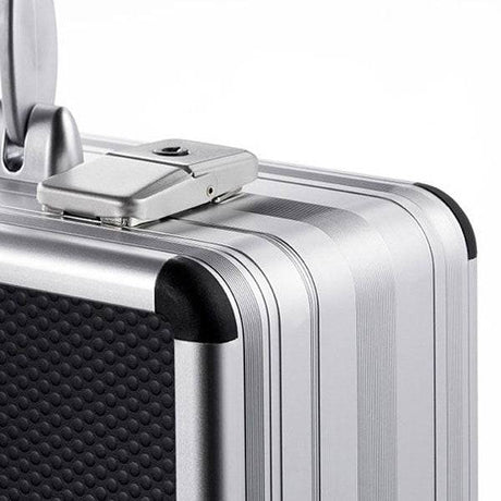 Close-up of the AZKE 95700: a silver aluminium frame case with a textured black panel, top-edge combination lock, and custom CNC foam fittings inside for added protection.