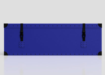 The Cricket Storage Poly Case (Medium) is a rectangular blue trunk with black corner protectors, two black webbing buckle straps, and a sturdy zinc drop handle, shown against a plain light background.
