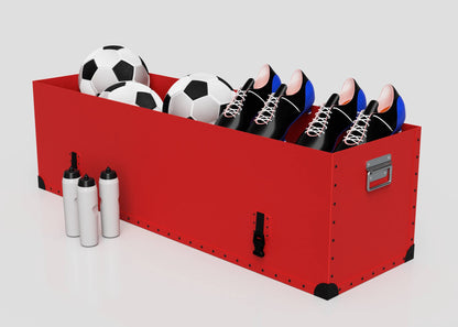 The Football Storage Poly Case (Large), in red with a zinc drop handle, holds two soccer balls and three pairs of soccer shoes; three water bottles are placed next to the case.