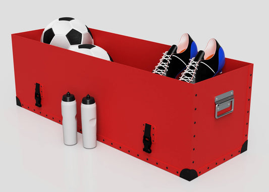 A Football Storage Poly Case (Medium) in red holds two soccer balls and a pair of black athletic shoes, with two white water bottles next to it.