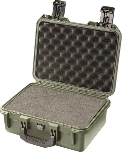 A green hard plastic iM2100 Storm Case with a black handle, shown open to reveal foam padding on the lid and base—this crushproof case offers rugged protection.