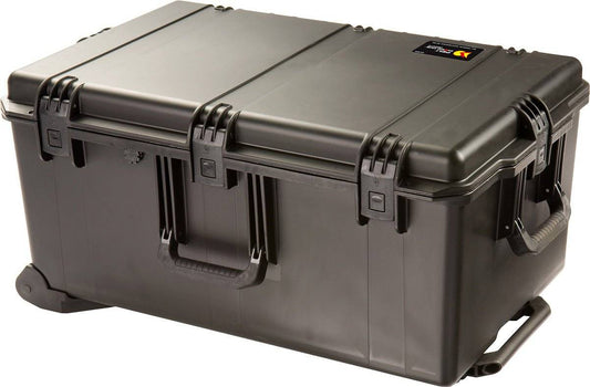 The iM2975 Storm Travel Case is a large black hard-shell case with Press and Pull latches, side handles, wheels for transport, and optional custom CNC foam fittings; shown closed on a white background.