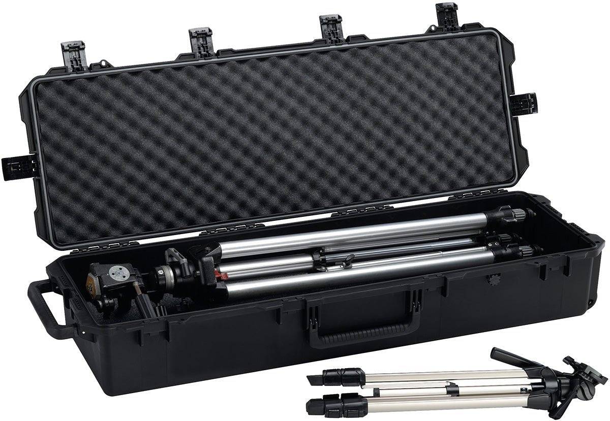 An open iM3220 Storm Long Case with custom CNC foam holds a folded tripod inside, while another tripod stands outside and in front of the case.