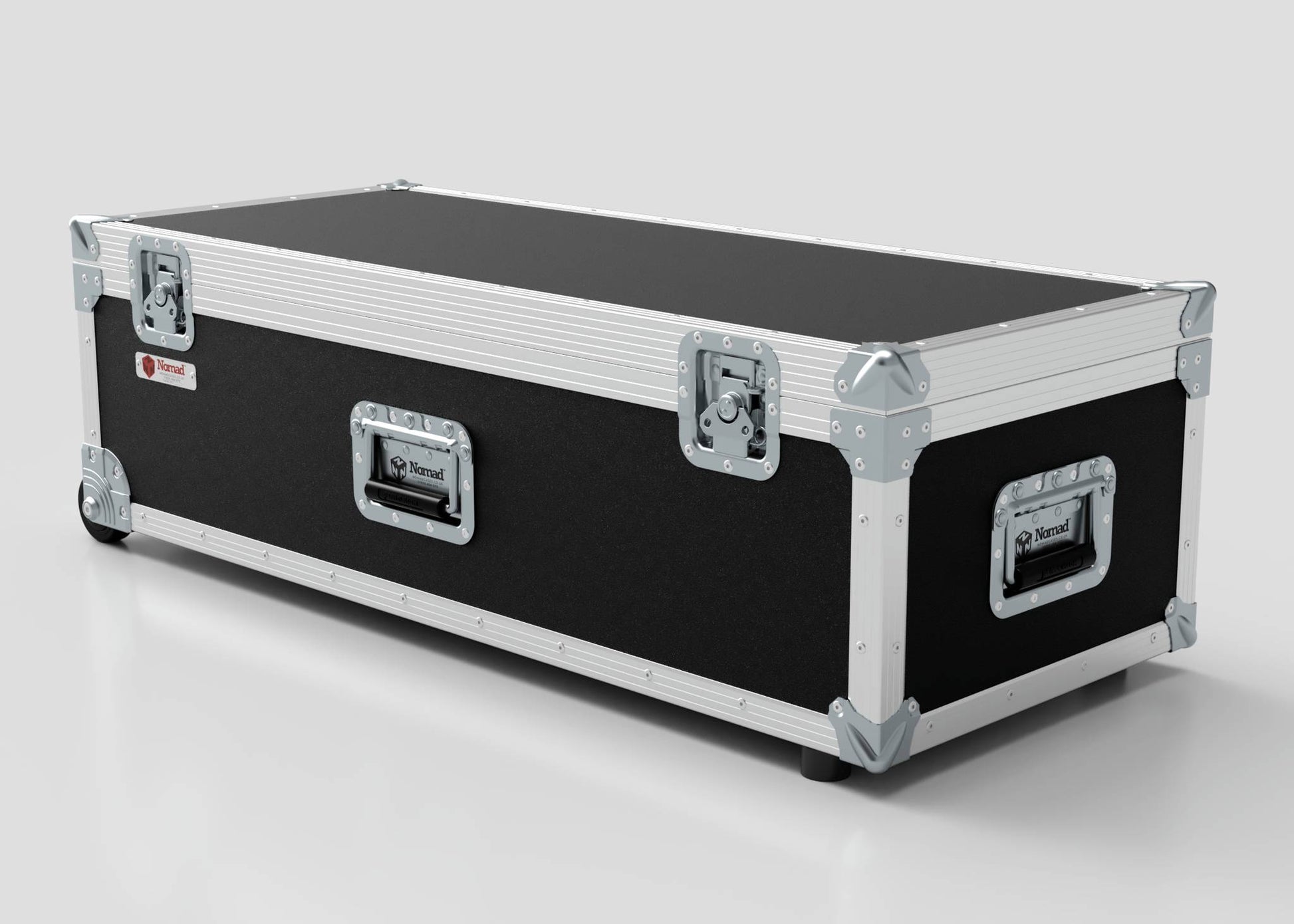 The Lid Maker Trunk Case, a large rectangular flight case in black and silver with metal reinforcements and handles, measuring 1010 x 400 x 410 mm externally, is set on a light gray surface.