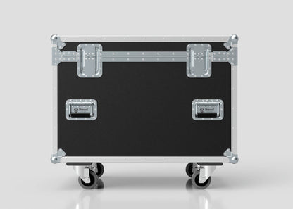 The MUT Trunk Case, in black and silver with metal reinforcements, latches, handles, and four caster wheels, features a variable divider system for organized storage. Shown against a plain light background.