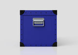 The Rugby Storage Poly Case (Medium) is a blue polyethylene box with black corner protectors, metal rivets, and a zinc drop handle on the front, shown against a plain white background.