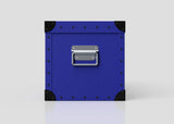 The Rugby Storage Poly Case (Small) is a blue metal box featuring black corner protectors, silver rivets, and a zinc drop handle on the front, displayed against a plain light gray background.