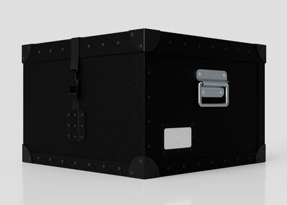 The Standard Cube Storage Box - Small is a black polyethylene box with metal corner reinforcements, a front latch, and a side handle, shown on a white surface.
