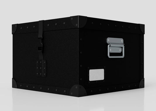 The Standard Cube Storage Box - Small is a black polyethylene box with metal corner reinforcements, a front latch, and a side handle, shown on a white surface.