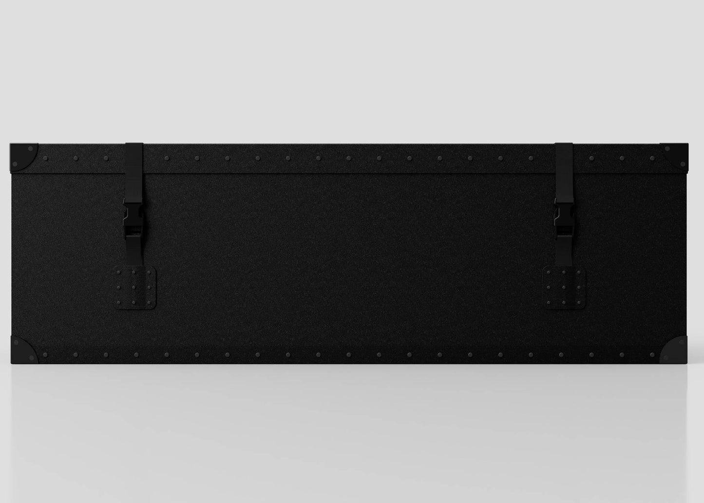 The Standard Long Storage Box - Medium is a large black rectangular case with metal corners, two webbing straps with side-release buckles, and rivet details, shown against a plain light gray background.
